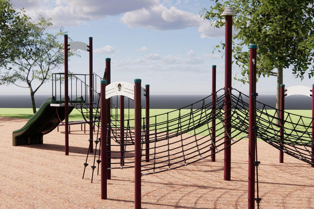 Playground with a climbing net structure, swings, and a slide set in a park. Surrounded by trees and grassy fields, with a cloudy sky in the background.