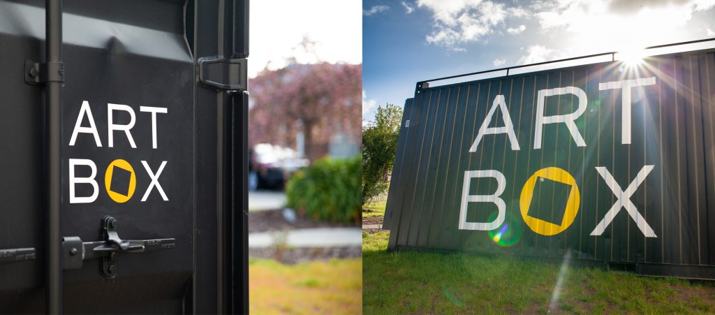 Split image: Left shows a close-up of a black container door with ART BOX in white letters; right shows a full view of a large black container with ART BOX and sun rays peeking over the top, with grass and clouds in the background.