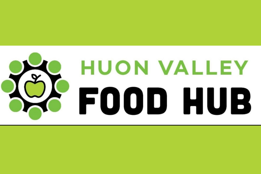 Logo of Huon Valley Food Hub, featuring a green apple inside a black circle surrounded by green dots. The background is light green.