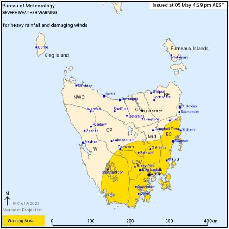Map showing Tasmania with severe weather warning areas in yellow, issued by the Bureau of Meteorology. The warning covers the southern and southeastern regions, including Hobart, with annotations for wind and rainfall concerns.