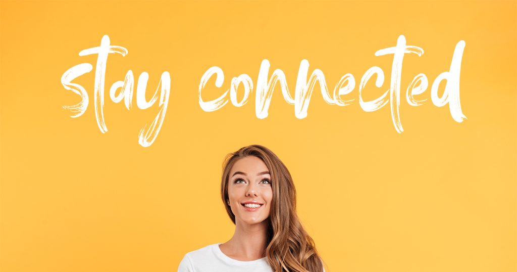A person with long hair smiles while looking upward against a bright yellow background. Above them, the phrase stay connected is written in large white script font.