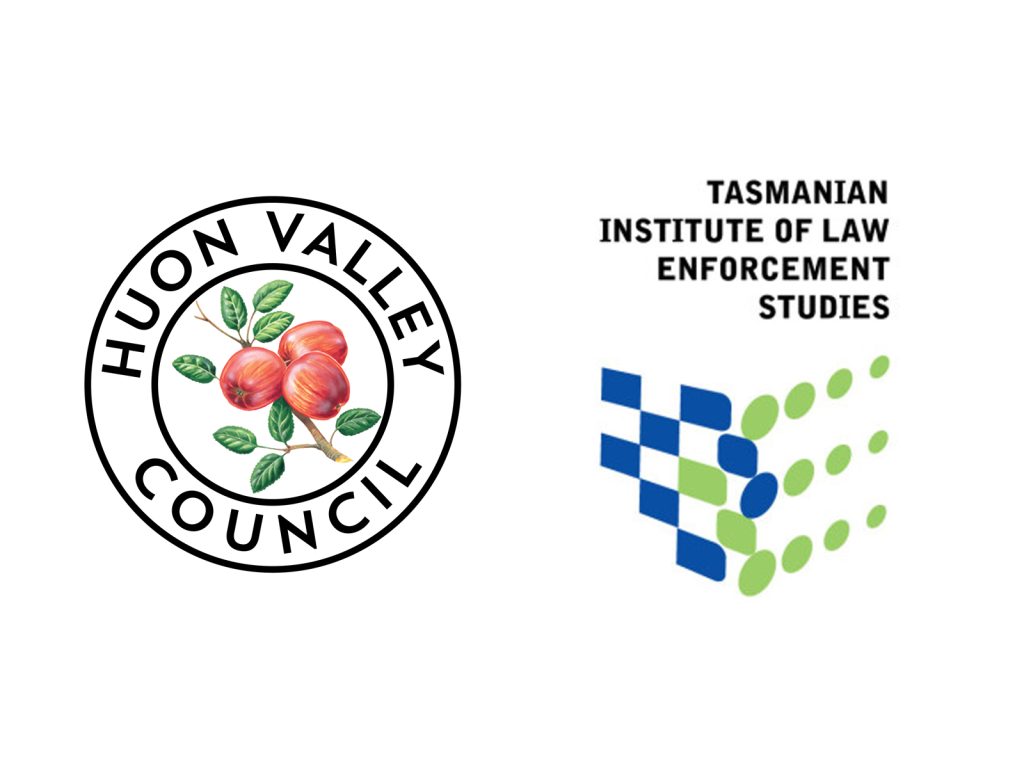 Logos of Huon Valley Council and Tasmanian Institute of Law Enforcement Studies. The Huon Valley Council logo features apples and leaves within a circular design. The Tasmanian Institute logo includes green and blue squares arranged in a dynamic pattern.