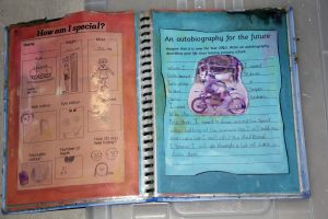 Open book with two pages. Left page contains personal information and drawings with the title How am I special? Right page titled An autobiography for the future includes a childs handwriting about a future career and drawing of a person on a motorcycle.