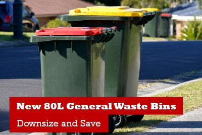 Two green waste bins with red and yellow lids are lined up on a suburban street. A red banner with white text reads New 80L General Waste Bins - Downsize and Save. Other bins are visible in the background.