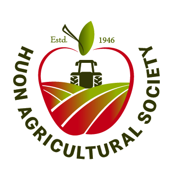 Logo of Huon Agricultural Society featuring a red apple with a green leaf, a tractor, and farm fields inside. Text Est. 1946 and HUON AGRICULTURAL SOCIETY surrounds the apple.