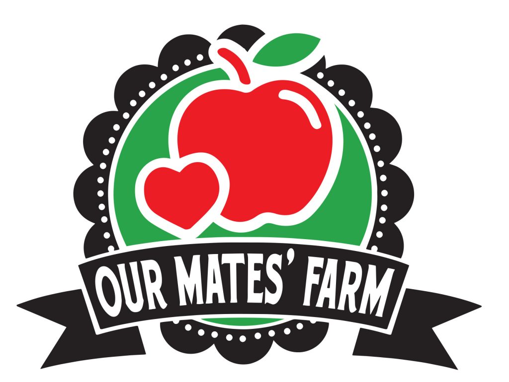 Logo featuring a red apple and a heart on a green circular background with a black scalloped border. A black ribbon across the bottom reads “OUR MATES’ FARM” in bold white letters.