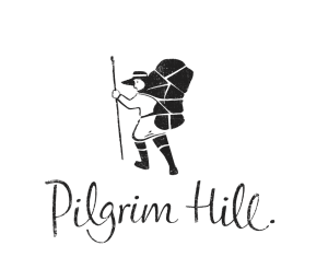 A hiker with a large backpack and walking stick is above the handwritten text Pilgrim Hill. The illustration is simple and in black and white.
