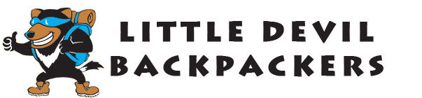 Cartoon devil bear wearing sunglasses, a backpack, and giving a thumbs-up next to the bold text LITTLE DEVIL BACKPACKERS on a light background.