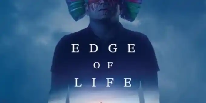 A person wearing a colorful, feathered mask stands in a blue mist. The words EDGE OF LIFE are centered over the image, fading into the background.