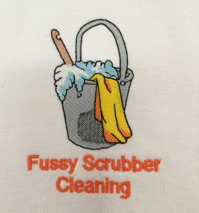 Embroidered design of a gray bucket with a mop, yellow rubber gloves, and blue suds, with the text Fussy Scrubber Cleaning in orange below.