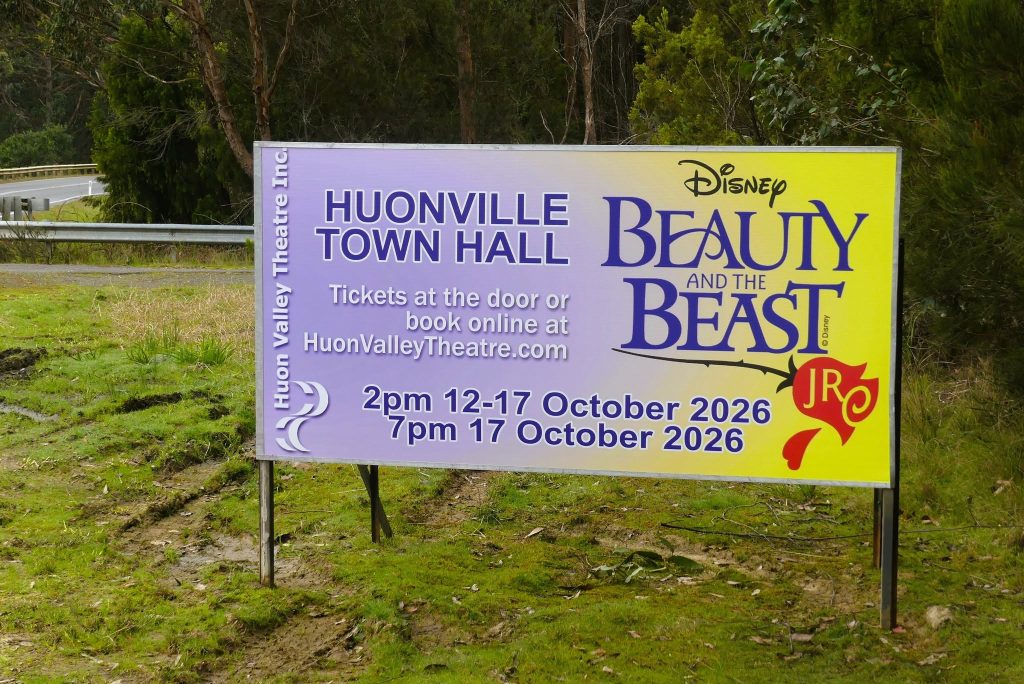 A sign for a Huonville Town Hall production of Disneys Beauty and the Beast, showing show dates on October 12-17, 2026, and a website for tickets.
